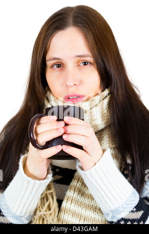 Giovane donna sorpresa freddo, avvolto in una coperta, bere qualcosa di caldo da cup. Foto Stock