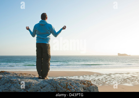 L'uomo meditando sulla spiaggia, Camaret-sur-Mer, Crozon Penisola, Finisterre, Bretagna Francia Foto Stock