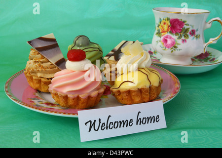 Benvenuti a casa nota, petit fours e tazza di tè Foto Stock