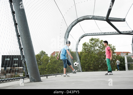 Ragazzi che giocano a calcio nel parco giochi, Mannheim, Baden-Württemberg, Germania Foto Stock