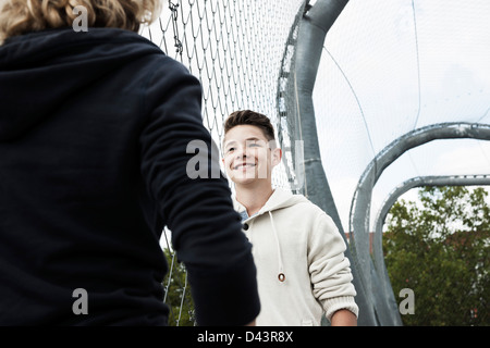 Ragazzo e una ragazza a parlare nel parco giochi, Mannheim, Baden-Württemberg, Germania Foto Stock