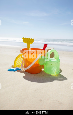 Toy benna, rastrello e Annaffiatoio in spiaggia, Cap Ferret, Gironde, Aquitaine, Francia Foto Stock