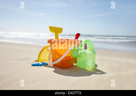 Toy benna, rastrello e Annaffiatoio in spiaggia, Cap Ferret, Gironde, Aquitaine, Francia Foto Stock