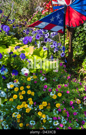 Fiori in giardino con bandiera americana girandola, a Provincetown, Cape Cod, Massachusetts, STATI UNITI D'AMERICA Foto Stock