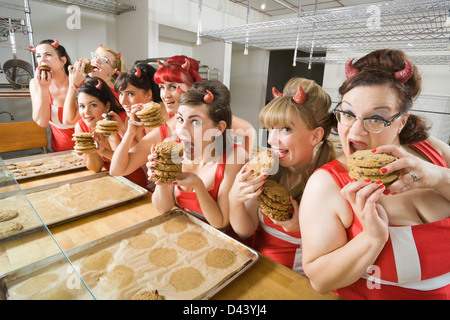 Donne che indossano diavolo corna in una pasticceria di Oakland, contea di Alameda, California, Stati Uniti d'America Foto Stock