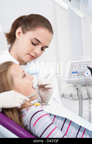 Dentista controllando la ragazza dei denti durante l'appuntamento, Germania Foto Stock