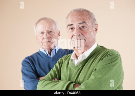 Ritratto di due alti uomini guardando la telecamera, Studio shot su sfondo beige Foto Stock