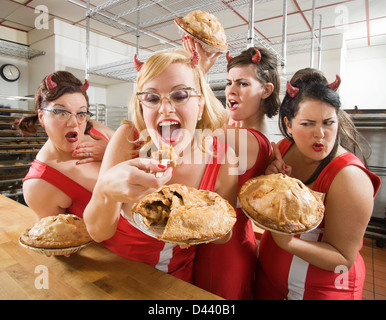 Donne che indossano diavolo corna in una pasticceria di Oakland, contea di Alameda, California, Stati Uniti d'America Foto Stock