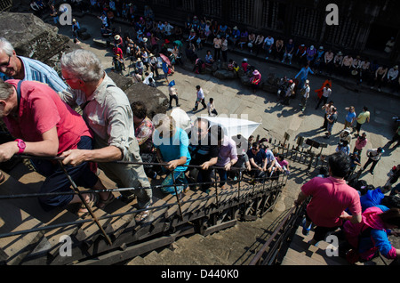 I turisti scalata di un tempio di Angkor Wat in Cambogia Foto Stock