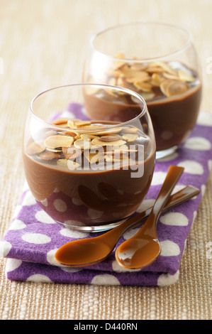 Close-up di bicchieri di budino di cioccolato con Slivered noci tostate Foto Stock