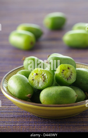 Close-up di ciotola di Mini Kiwi con uno tagliati a metà Foto Stock