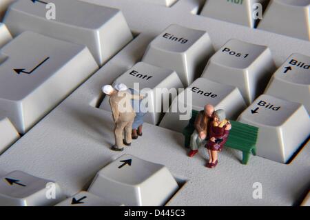 Illustrazione - le cifre in miniatura di due coppie di pensionati sono raffigurate davanti al tasto 'Ende' (fine) su una tastiera del PC, a Berlino, Germania, 29 dicembre 2007. Fotoarchiv für ZeitgeschichteS.Steinach Foto Stock
