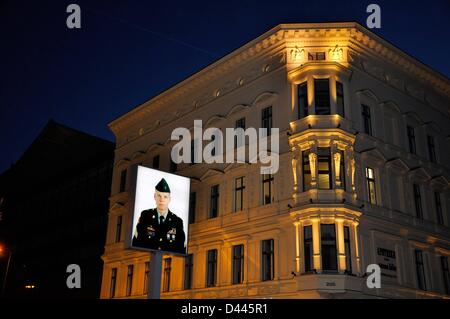 Ritratto di un giovane soldato americano all'ex posto di frontiera Checkpoint Charlie a Berlino, Germania, 8 marzo 2011. Sul retro dell'immagine illuminata, c'è un ritratto di un giovane soldato sovietico. L'installazione del fotografo Frank Thiel dal 1994 indicava l'ex confine interno-tedesco tra il settore americano e sovietico della città. Fotoarchiv für ZeitgeschichteS.Steinach Foto Stock