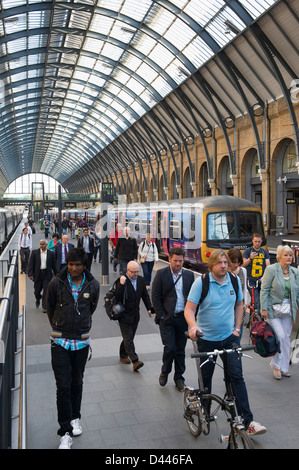 I passeggeri di sbarco da un recentemente arrivati in treno presso la stazione di Kings Cross a Londra, Inghilterra. Foto Stock