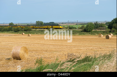 Rete giallo manutenzione ferroviaria treno che viaggia attraverso la splendida campagna inglese. Foto Stock