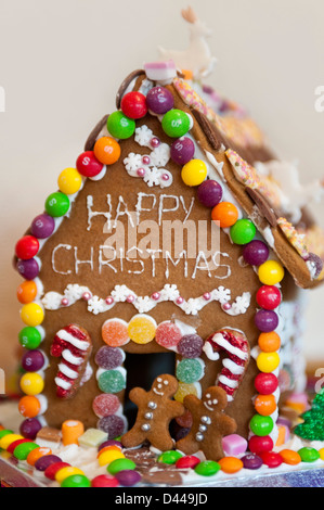 Verticale fino in prossimità di una casa di panpepato decorato per il Natale con alberi di Natale e di neve. Foto Stock