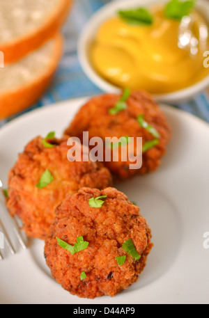 Polpettine di carne con mostarda sul piatto bianco Foto Stock