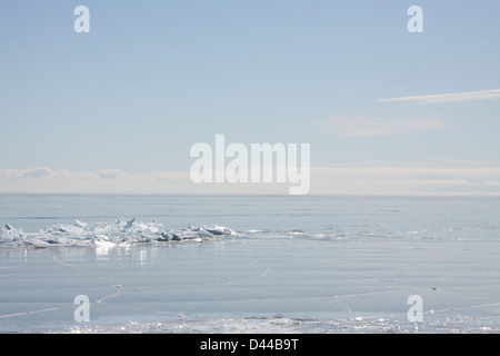 Massa di pezzi di ghiaccio formando una pila su un banco di sabbia in fondali bassi di un grande lago. Foto Stock