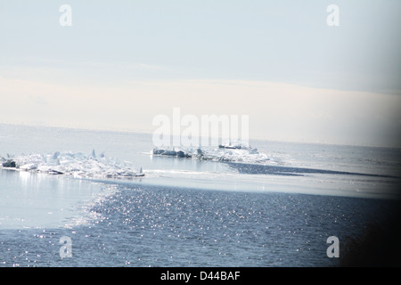 Massa di pezzi di ghiaccio formando una pila su un banco di sabbia in fondali bassi di un grande lago. Foto Stock