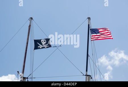 Bandiere di Stati Uniti d'America e il cranio e spade incrociate volare da alberi di nave Foto Stock