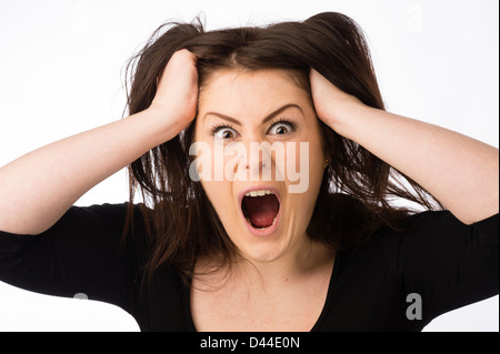 Un giovane arrabbiato grida donna, lacerazione tirando fuori il suo marrone capelli fuori , REGNO UNITO Foto Stock