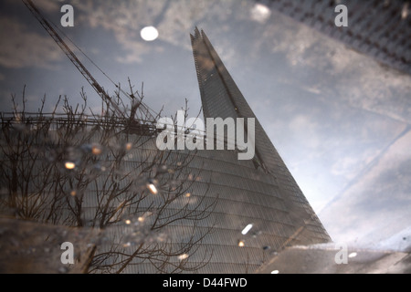 Foto di shard riflessa in una pozza in un giorno di pioggia a Londra Foto Stock