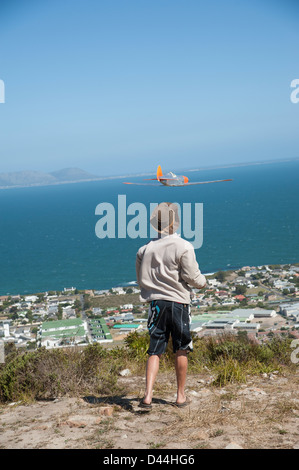 Ragazzo battenti una radio controlled glider dal modo rotante sopra Hermanus Western Cape Sud Africa modello piano appassionato di aeromobili Foto Stock