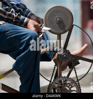 L'uomo l'affilatura coltelli e forbici per strada in Nepal Foto Stock