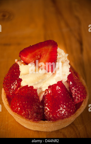 Torta di fragole con panna su una tavola di legno Foto Stock