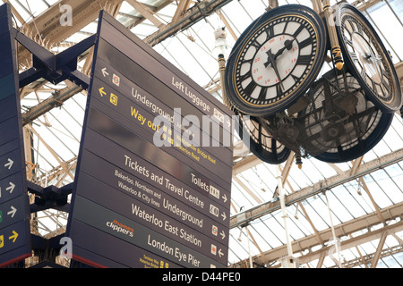 Segni sospesi e orologio presso la stazione di Waterloo, London, England, Regno Unito Foto Stock