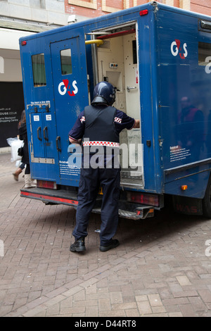 Servizi di riscossione del contante in transito G4S. Guardia di sicurezza che carica il furgone attraverso la porta posteriore del veicolo blindato DataTrak a Blackpool, Lancashire, Regno Unito Foto Stock