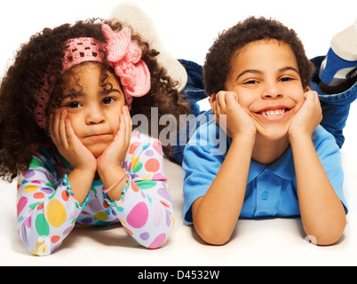 Bella black fratello e sorella e con un grande sorriso la posa sul pavimento Foto Stock