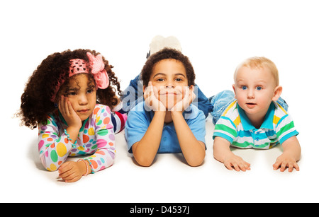 Due anni ragazza nera con il fratello più anziano e Caucasico ragazzino che stabilisce insieme sul pavimento Foto Stock