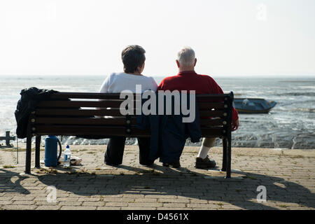 Southend, Essex, Regno Unito. Il 5 marzo 2013. Le persone godono della unseasonably giornata calda. Seduta su una panchina nel vecchio Leigh, una coppia senior guardando fuori attraverso l'estuario del Tamigi a Kent al sole. Credito: Allsorts Stock Photo / Alamy Live News Foto Stock