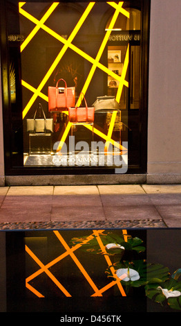 Giorgio Armani boutique designer store illuminata la finestra di visualizzazione e di riflessione Via Montenapoleone Milano Lombardia Italia Europa Foto Stock