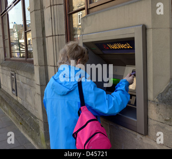 Un cliente che utilizza un bancomat Foto Stock