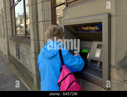 Un cliente che utilizza un bancomat Foto Stock