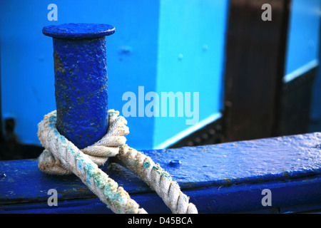 Una barca blu legato con una corda Foto Stock