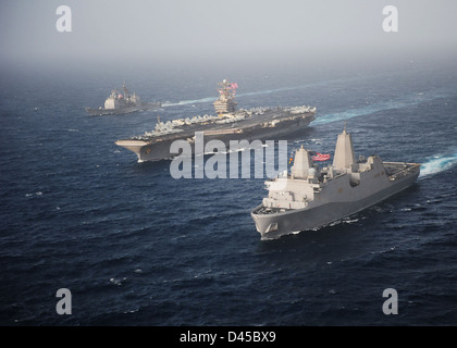 La USS New York, la USS Abraham Lincoln e la USS Cape St. George transitano in formazione nel Mar Arabico, mostrando il coordinamento navale e la forza durante un'operazione militare. Foto Stock