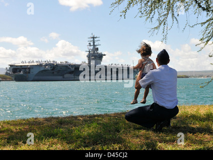 Un capitano dell'aeronautica e sua figlia osservano la USS Nimitz (CVN 68) mentre arriva alla Joint base Pearl Harbor-Hickam, Hawaii, come parte delle esercitazioni militari del RIMPAC. Foto Stock