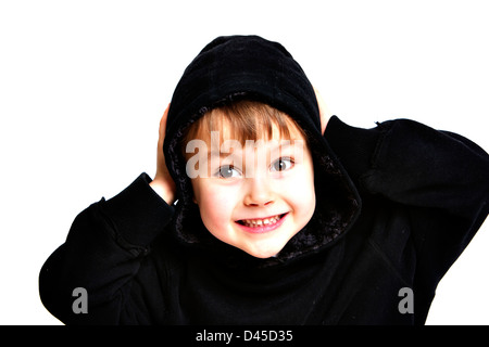 Giovane ragazzo in un nero felpa con cappuccio Felpa con sallow pelle marrone capelli e gli occhi castani contro uno sfondo bianco facendo facce per la fotocamera Foto Stock