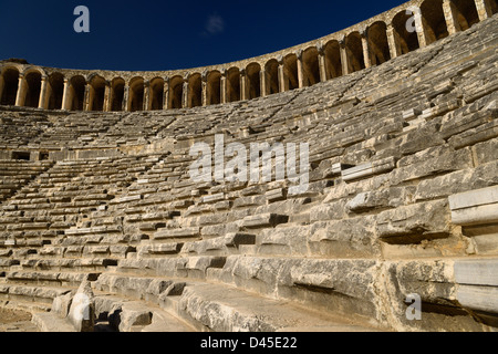 Vista di pietra semicircolare posti in antico teatro romano di Aspendos dal palco con galleria superiore archi in Turchia Foto Stock