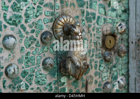 Metallo a mano a forma di porta respingente su una vecchia porta di legno con incrinato vernice turchese nella vecchia città di Moulay Idriss, Marocco Foto Stock