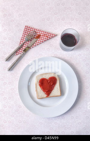 Una fetta di pane tostato con un cuore di ketchup Foto Stock