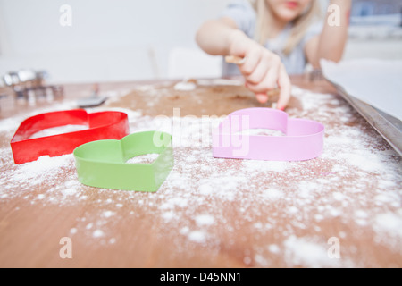 Ragazza giovane la preparazione di panpepato pasta biscotto con cuore frese sagomate in primo piano Foto Stock