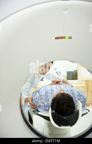 Un paziente sta andando attraverso uno scanner TC Foto Stock