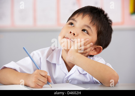 Maschio di studenti che lavorano alla reception in cinese aula scolastica Foto Stock