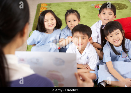 Insegnante che mostra la pittura per gli studenti cinesi in aula scolastica Foto Stock