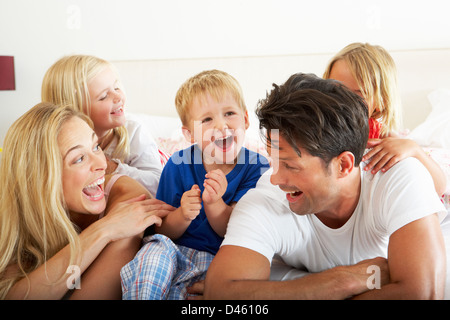 Famiglia rilassante insieme a letto Foto Stock