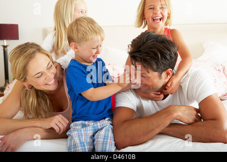 Famiglia rilassante insieme a letto Foto Stock